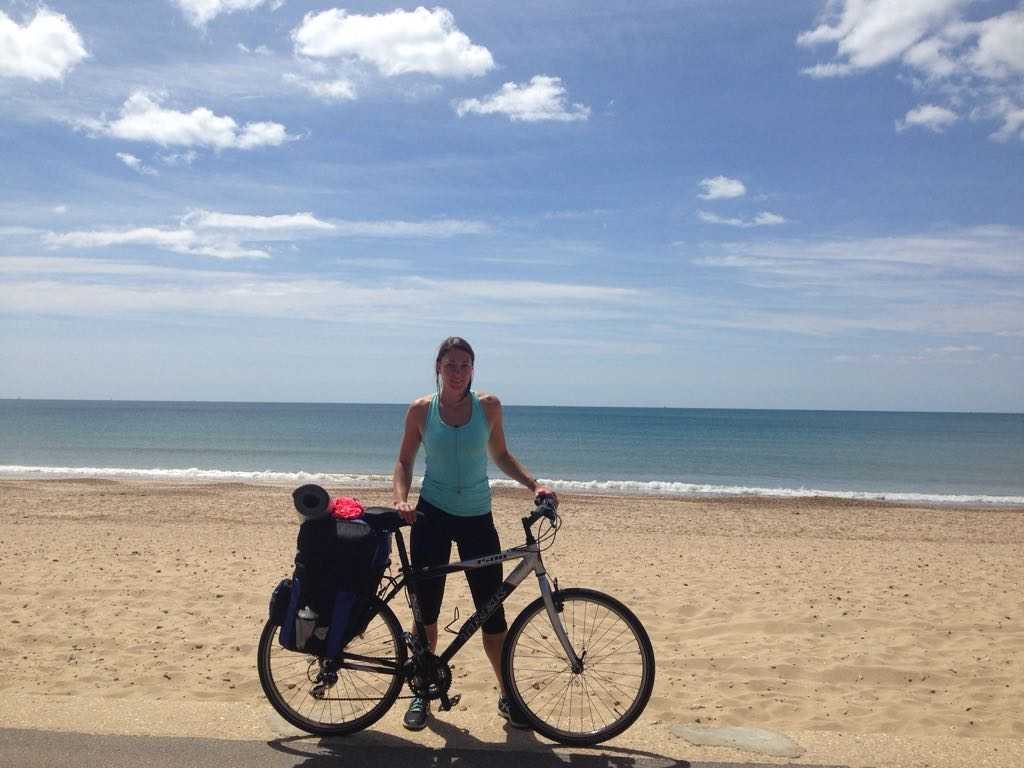 A photo of Emma Brown, physiotherapist with Central Health Physiotherapy, with her bicycle on the beach