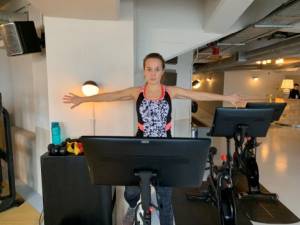 Lucy Rix, Central Health Physiotherapy, showing an exercise for cycling, stretching out her arms.
