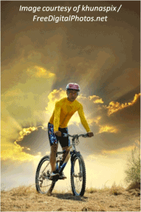 A man mountain biking in the sunset